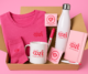 Pack de productos promocionales personalizados con logotipo de Ozé Creative Studio, incluyendo camiseta, calcetines, taza, libreta, bolígrafo, pegatinas y botella, sobre fondo rosa.