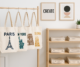 Tote bags personalizadas colgadas en un perchero, con diseños gráficos de monumentos de París, Nueva York, Roma y Barcelona