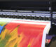 Impresora industrial de gran formato de imprenta online imprimiendo diseño con plumas coloridas en alta resolución