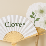 Abanico plegable personalizado con logotipo Clove y abanico japonés pai pai con ilustración floral.